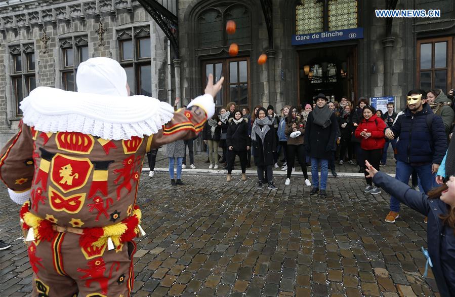 A 'Gille' throws oranges symbolizing the coming Spring to visitors, in Binche, Belgium, on Feb. 28, 2017.