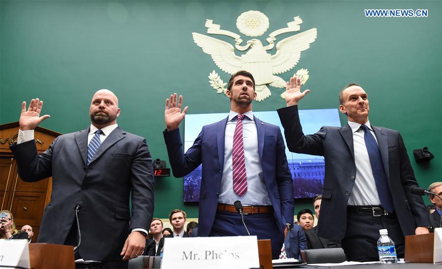 U.S. Olympic gold medalists Michael Phelps (C) and Adam Nelson (L) take an oath before testifying at the House Energy and Commerce Subcommittee on Oversight and Investigations during a hearing on 'Ways to Improve and Strengthen the International Anti-Doping System' on the Capitol Hill in Washington D.C., the United States, Feb. 28, 2017. 