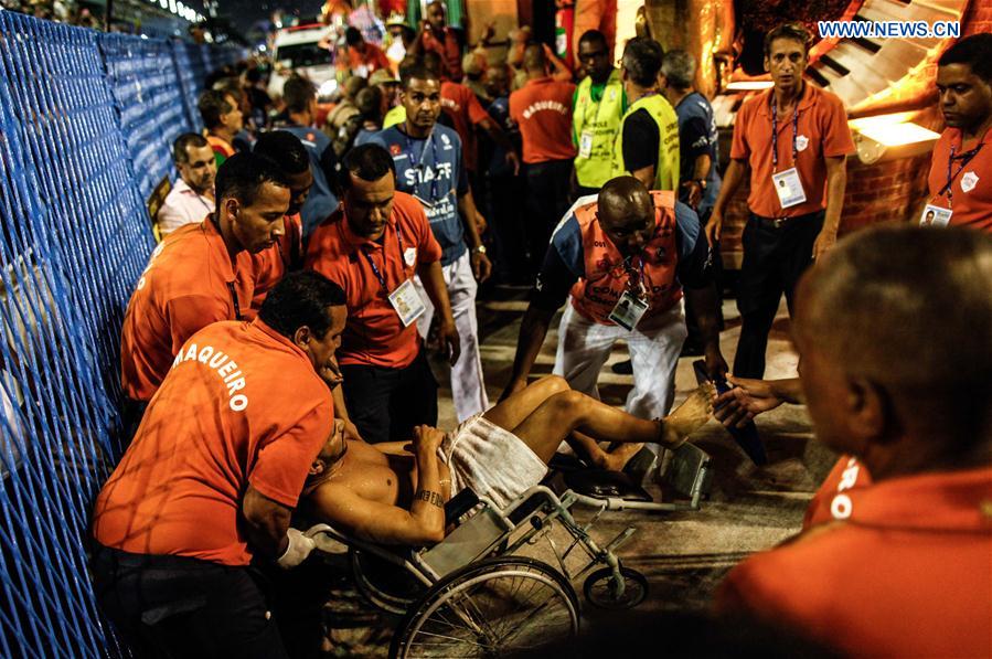 Employees help an injured man after the collapse of the top of an allegorical car of the samba school Unidos da Tijuca during the Carnival parade as it advanced through the Marques de Sapucai Avenue, in downtown Rio de Janeiro, Brazil, on Feb. 28, 2017.  
