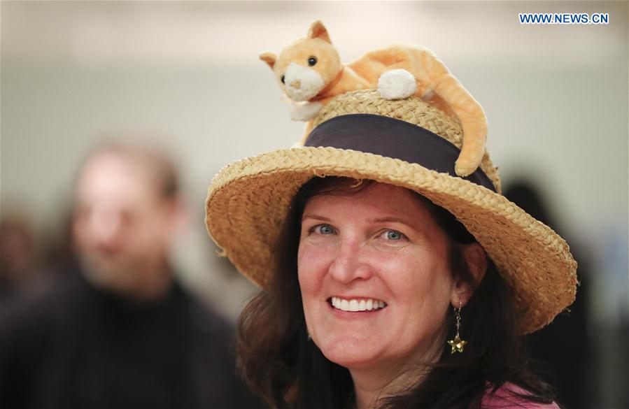 A visitor with a cat decoration on her hat attends the Cat Camp in New York, the United States, on March 11, 2017. 