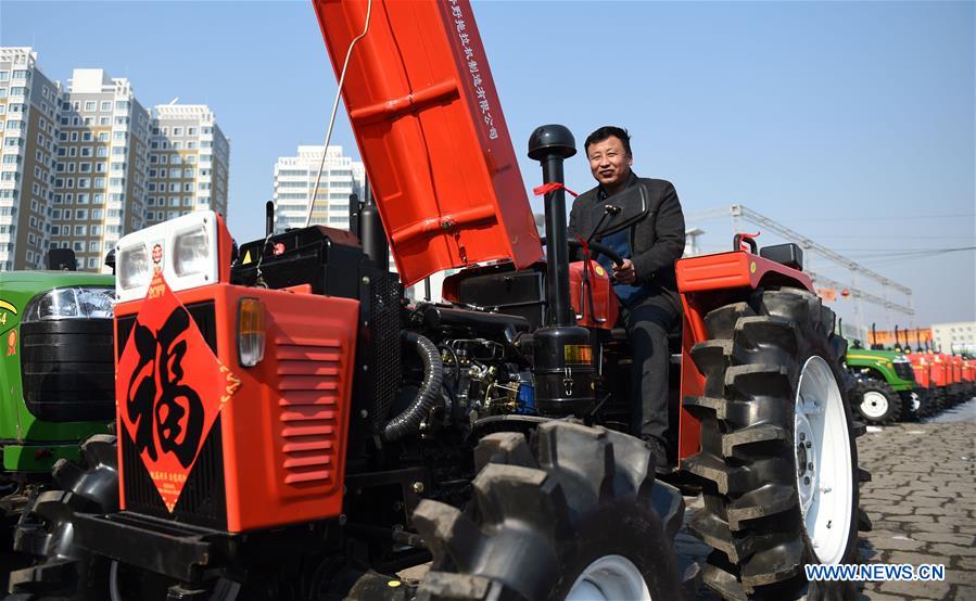 A farmer tries a tractor at a market in Harbin, northeast China's Heilongjiang Province, March 16, 2017. Farmers in Heilongjiang began to choose agricultural machinery on the market for the upcoming spring ploughing. (Xinhua/Wang Jianwei) 