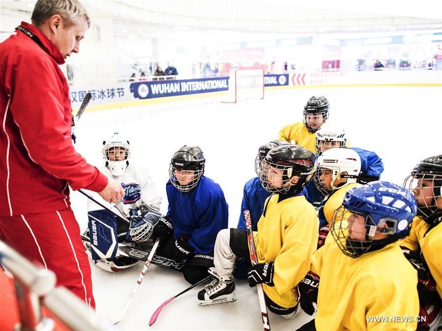 Photo taken on Feb. 25, 2017 shows ice hockey players of Binglong International Skating Club listening to their Russian coach Nikolaev Vladimir at a skating rink in a shopping mall in Wuhan, central China's Hubei Province. Keeping up a sound and steady pace of development, the Chinese sports industry was booming in 2016. The National Fitness Program (2016-2020) and the 13th Five-year Plan on the Sports Industry were both issued in 2016 to offer a clear direction for China's national strategy of ensuring public fitness and the development of the sports industry. China's General Administration of Sport, jointly with many other national governmental departments, also published policies and plans on winter sports. It released a plan on Nov. 2, 2016 to speed up the construction of winter sports infrastructure, aiming to build at least 500 skating rinks before the 2022 Winter Olympic Games. Four of six ski resorts are built in Shennongjia. During season 2016-2017, Shennongjia Ski resort accommodated more than 120,000 tourists, up 35 percent from 2015. A winter sports training base is planned to construct in Shennongjia for traning professional athletes. Around 2,000 people regularly participate in skating sports at five rinks in Wuhan, capital of Hubei Province every year. (Xinhua/Xiao Yijiu)