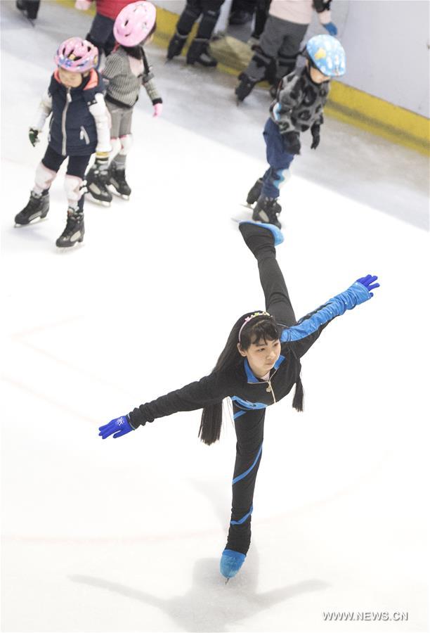 Photo taken on March 4, 2017 shows Jiang Xingyu (L) learning skating from his Russian coach Vsevolod Popov of Binglong International Skating Club at a skating rink in a shopping mall in Wuhan, central China's Hubei Province. Keeping up a sound and steady pace of development, the Chinese sports industry was booming in 2016. The National Fitness Program (2016-2020) and the 13th Five-year Plan on the Sports Industry were both issued in 2016 to offer a clear direction for China's national strategy of ensuring public fitness and the development of the sports industry. China's General Administration of Sport, jointly with many other national governmental departments, also published policies and plans on winter sports. It released a plan on Nov. 2, 2016 to speed up the construction of winter sports infrastructure, aiming to build at least 500 skating rinks before the 2022 Winter Olympic Games. Four of six ski resorts are built in Shennongjia. During season 2016-2017, Shennongjia Ski resort accommodated more than 120,000 tourists, up 35 percent from 2015. A winter sports training base is planned to construct in Shennongjia for traning professional athletes. Around 2,000 people regularly participate in skating sports at five rinks in Wuhan, capital of Hubei Province every year. (Xinhua/Xiao Yijiu)