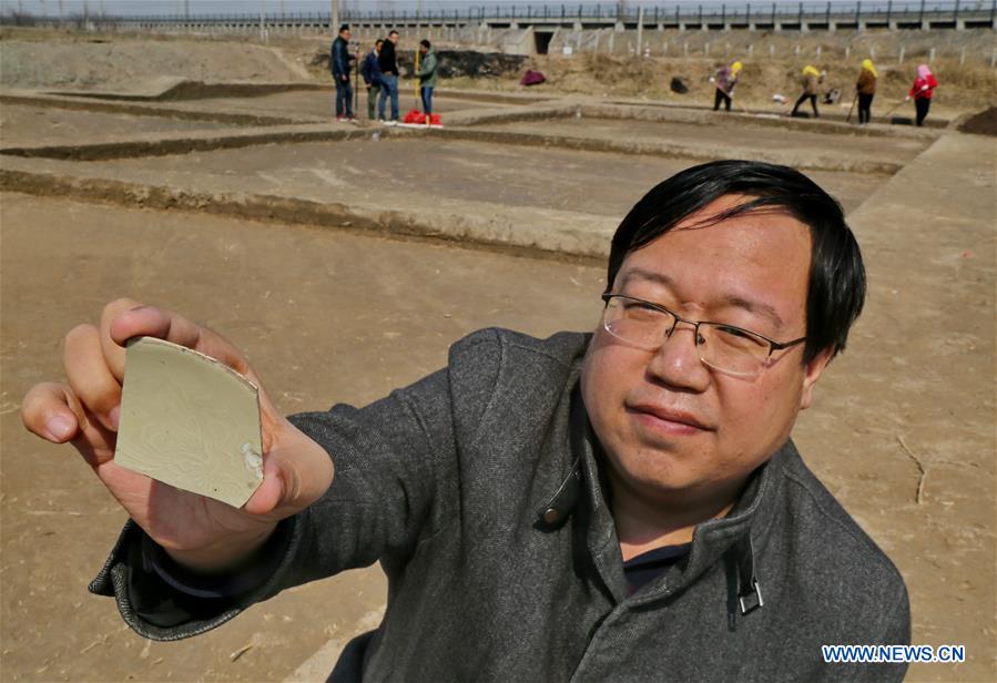 An archaeologist displays a scrap of broken porcelain at the ancient Haifeng town ruins site in Huanghua, north China's Hebei Province, March 17, 2017. Chinese archaeologists began the second-stage excavation of the ruins here, expecting to unveil functions of the town as an important trade port during the Jin (1115-1234) and Yuan (1271-1368) dynasties in Chinese history. (Xinhua/Yang Shiyao)