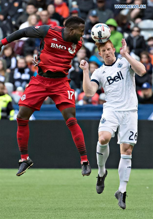 Toronto FC's Jozy Altidore (L) competes for a header with Vancouver Whitecaps' Tim Parker during a Major League Soccer (MLS) game between Toronto FC and Vancouver Whitecaps in Vancouver, Canada, on March 18, 2017.
