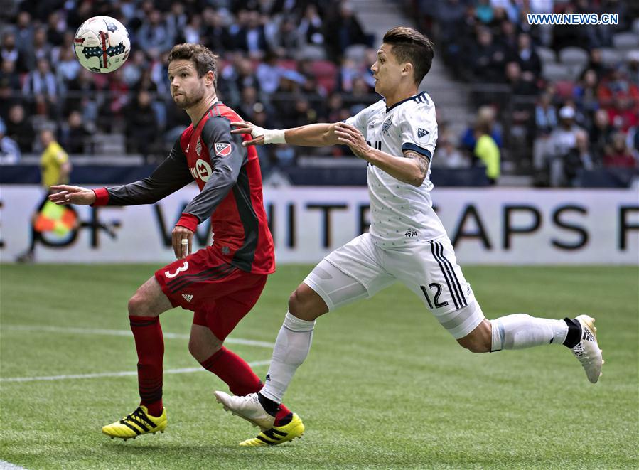 Toronto FC's Drew Moor (L) vies with Vancouver Whitecaps' Fredy Montero during a Major League Soccer (MLS) game between Toronto FC and Vancouver Whitecaps in Vancouver, Canada, on March 18, 2017. 