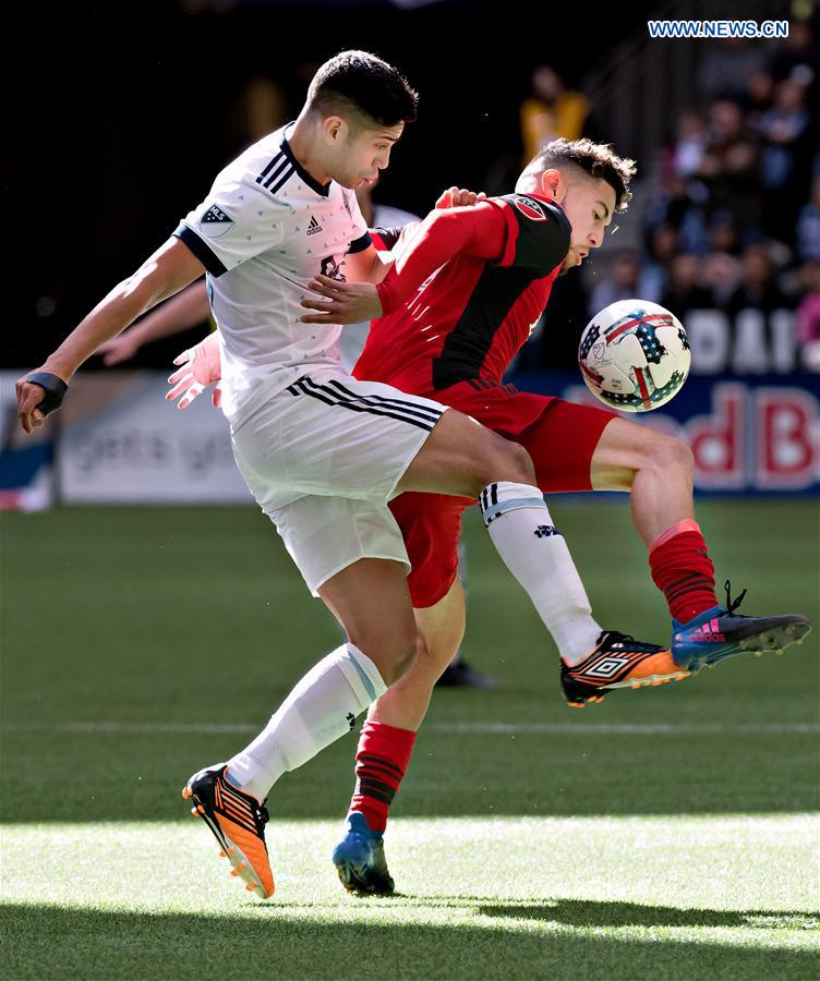 Toronto FC's Jonathan Osario (R) vies with Vancouver Whitecaps' Matias Laba during a Major League Soccer (MLS) game between Toronto FC and Vancouver Whitecaps in Vancouver, Canada, on March 18, 2017. 