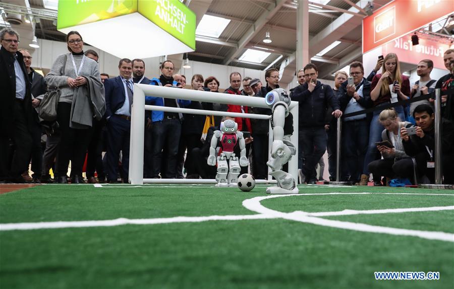 Robots play football at the booth of German Research Center for Artificial Intelligence during the CeBIT 2017 in Hanover, Germany, on March 20, 2017. The world's leading trade fair showcasing IT and communications products and solutions CeBIT 2017 kicked off on Monday and will last until March 24. The show with the theme 'd!conomy - no limits' this year attracted around 3,000 exhibitors from 70 countries and regions and is expected to attract some 200,000 visitors. (Xinhua/Shan Yuqi) 