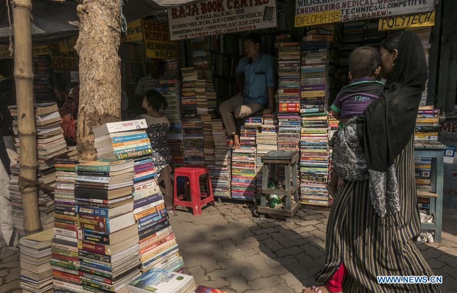 An Indian woman walks past a bookshop on College Street in Kolkata, capital of eastern Indian state West Bengal, on March 20, 2017. (Xinhua/Tumpa Mondal) 