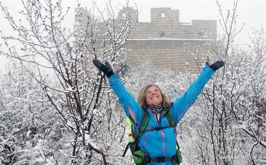 A foreign tourist poses for photos at snow-covered Huanghuacheng Lakeside Great Wall Reserve in the suburban district of Huairou in Beijing, capital of China, March 24, 2017. A snowfall hit the district on Friday. (Xinhua/Bu Xiangdong) 