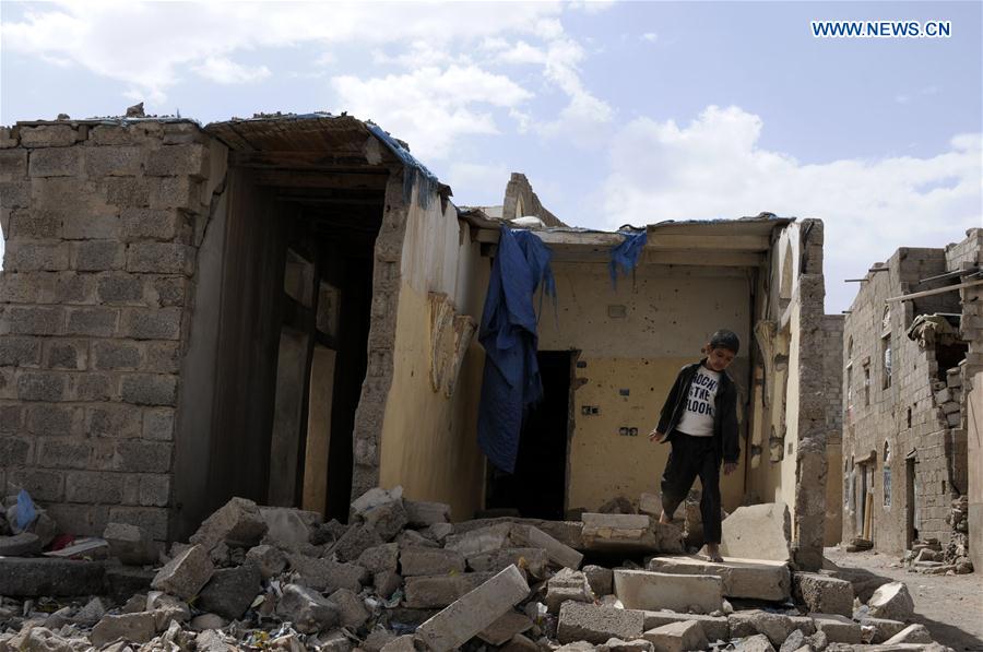 A boy walks on the rubble of a house destroyed in airstrikes at the Airport district in Sanaa, capital of Yemen, a day before the second anniversary of the military intervention in Yemen, on March 25, 2017.