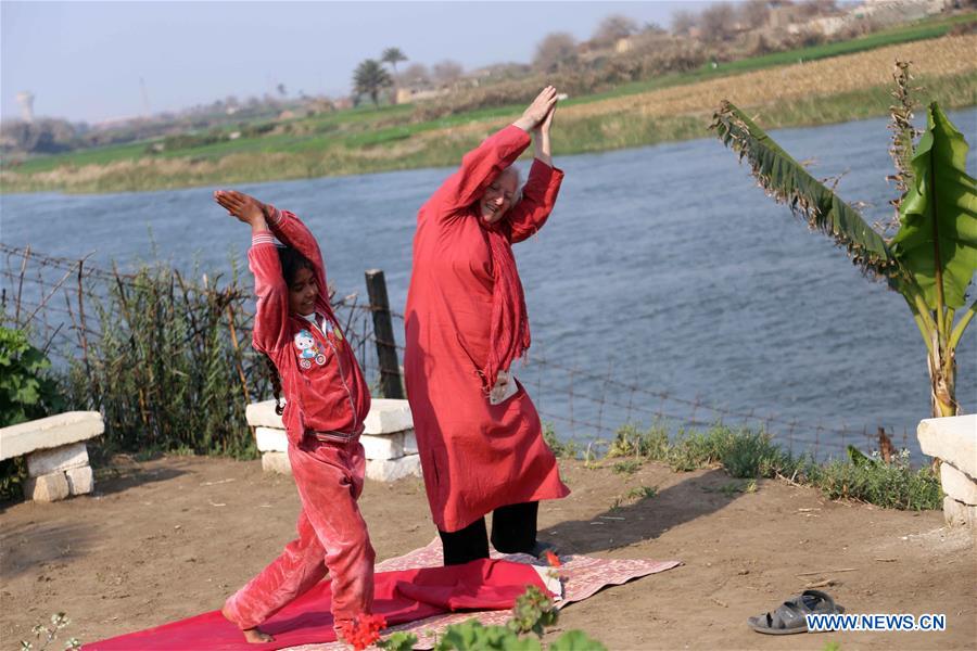 Lady Didi (R) teaches an Egyptian girl yoga at her Nile River School in Ayyat district on the outskirts of Giza Province, about 100 km south of Cairo, capital of Egypt, on March 26, 2017. Diana Sandor, known as Didi, an old Hungarian-born German-raised woman, covered the long distance from West to East six years ago to open her Nile River School as a charitable kindergarten and educational center at the heart of remote, impoverished Baharwa village of Ayyat district on the outskirts of Giza Province, about 100 km south of the Egyptian capital Cairo. Didi said she started building the center 'brick by brick,' through little donations from friends and volunteers around the world and that she is concerned with 'teaching children life,' not just languages and skills. (Xinhua/Ahmed Gomaa) 