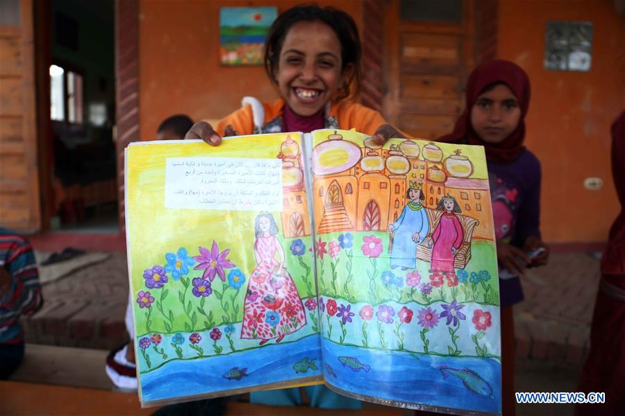 An Egyptian girl displays her painting work at lady Didi's Nile River School in Ayyat district on the outskirts of Giza Province, about 100 km south of Cairo, capital of Egypt, on March 26, 2017. Diana Sandor, known as Didi, an old Hungarian-born German-raised woman, covered the long distance from West to East six years ago to open her Nile River School as a charitable kindergarten and educational center at the heart of remote, impoverished Baharwa village of Ayyat district on the outskirts of Giza Province, about 100 km south of the Egyptian capital Cairo. Didi said she started building the center 'brick by brick,' through little donations from friends and volunteers around the world and that she is concerned with 'teaching children life,' not just languages and skills. (Xinhua/Ahmed Gomaa) 
