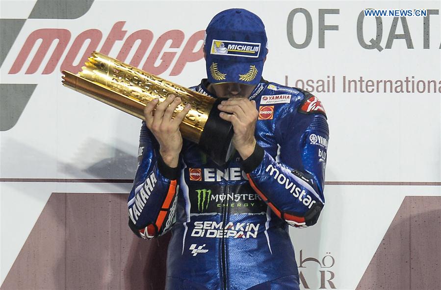 Movistar Yamaha MotoGP's Spanish rider Maverick Vinales kisses the trophy during the awarding ceremony for the 2017 FIM MotoGP Grand Prix of Qatar at the Losail International Circuit in Doha, capital of Qatar, on March 26, 2017. 