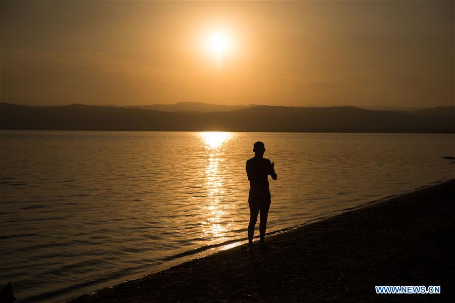  A Jordanian is silhouetted against sunset on the bank of Dead Sea near Sweimeh Village, Jordan, on March 28, 2017. (Xinhua/Meng Tao) 