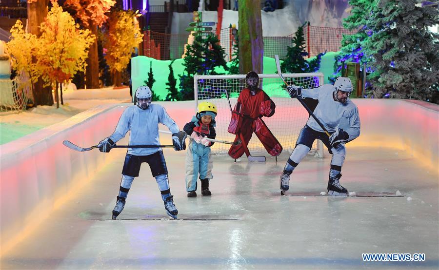 A girl plays ice hockey in 'Snow Wonder Land' at an oulet mall in Changsha, capital of central China's Hunan Province, on Feb. 25, 2017.