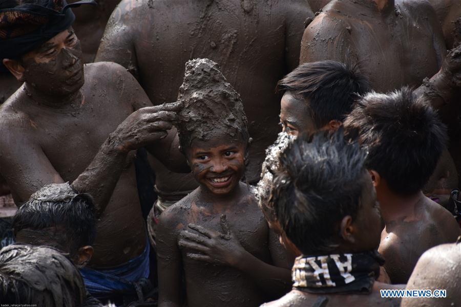 Balinese men put mud on a boy's body during mud baths tradition known as Mebuug-buugan, in Bali, Indonesia, March 29, 2017. The Mebuug-buugan is held a day after Nyepi aimed at neutralizing bad traits. (Xinhua/Kadek) 