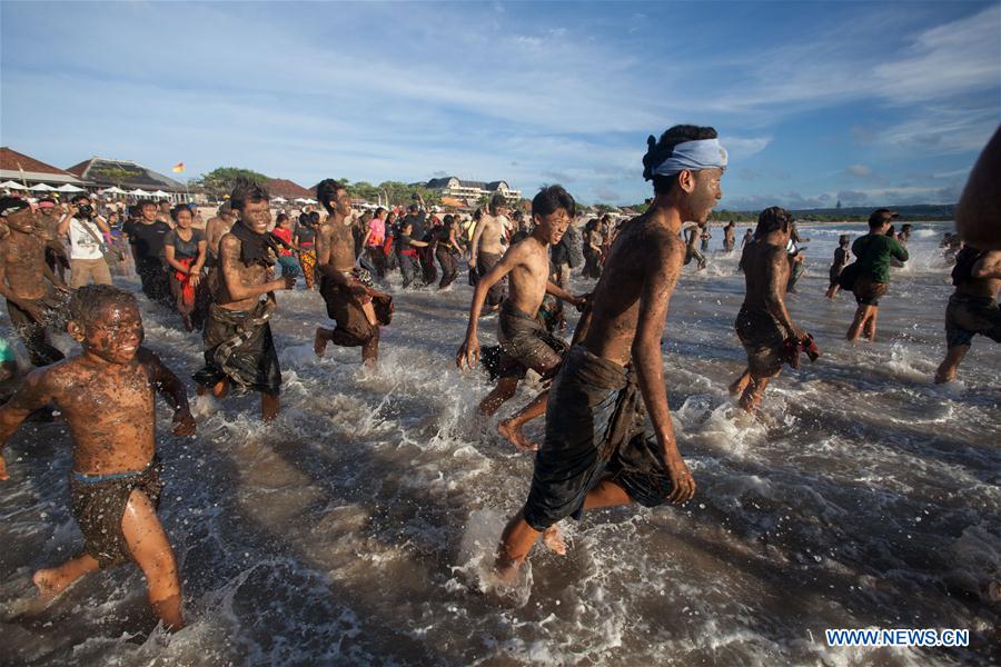 Balinese people run to the beach for cleaning their bodies after mud baths tradition known as Mebuug-buugan, in Bali, Indonesia, March 29, 2017. The Mebuug-buugan is held a day after Nyepi aimed at neutralizing bad traits. (Xinhua/Kadek) 