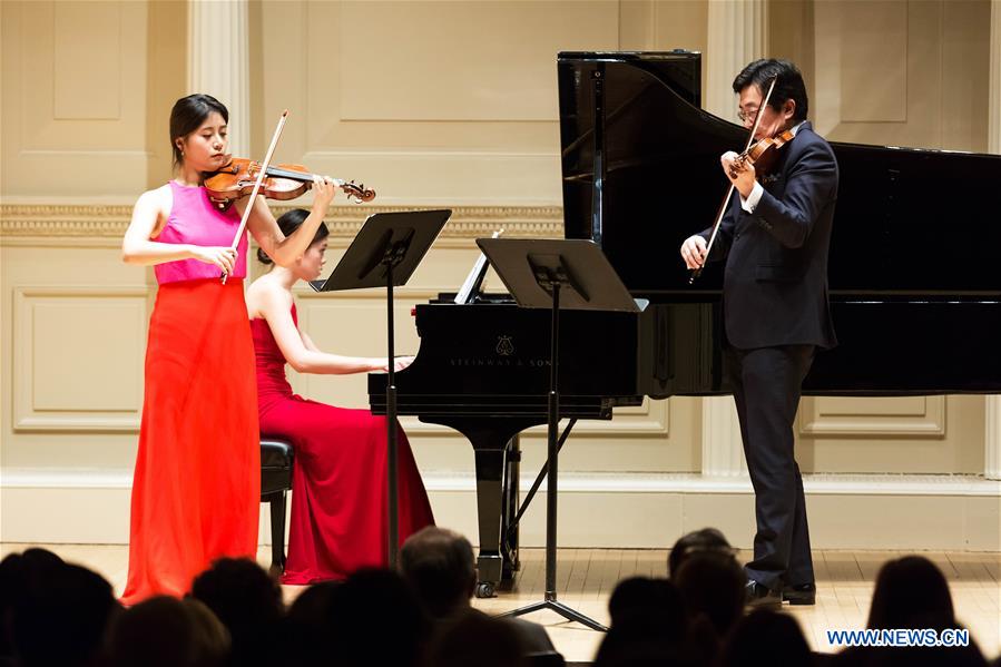 Chinese violinist Wang Jiazhi (L) performs with violinist Li Weigang during Wang Jiazhi's Carnegie Hall debut in New York, the United States, March 28, 2017. As a prize-winner of the Washington International Competition and China Young Artist Competition, Wang Jiazhi has appeared at music festivals around the world as soloist, recitalist and chamber musician. (Xinhua/Tang Siyu) 