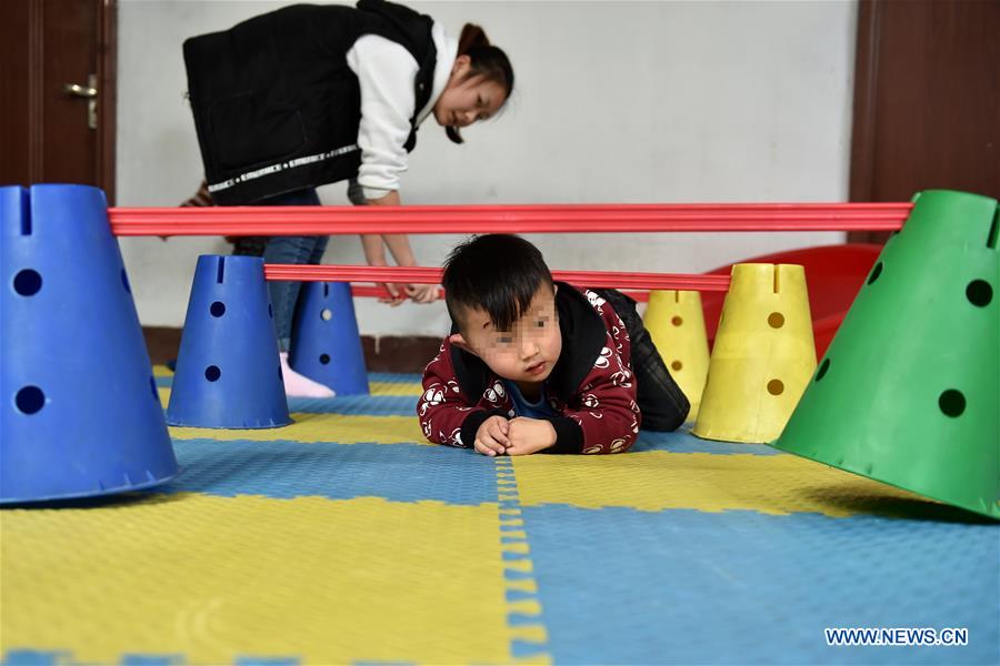 A teacher works during a sensory integration training for autistic children at a service center of the Lingxing community in Taiyuan, capital of north China's Shanxi Province, March 28, 2017. Established in 2010, the service center has accommodated over 60 children with autism. A total of 29 teachers take part in the rehabilitation program to help these children. April 2 marks the World Autism Awareness Day. (Xinhua/Zhan Yan) 
