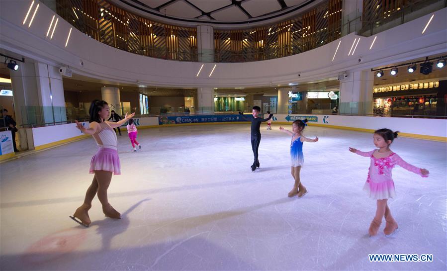 Coach Ge Qian (L) teaches children figure skating in the Century Star Rink in Kunming, capital of southwest China's Yunnan province, March 9, 2017.