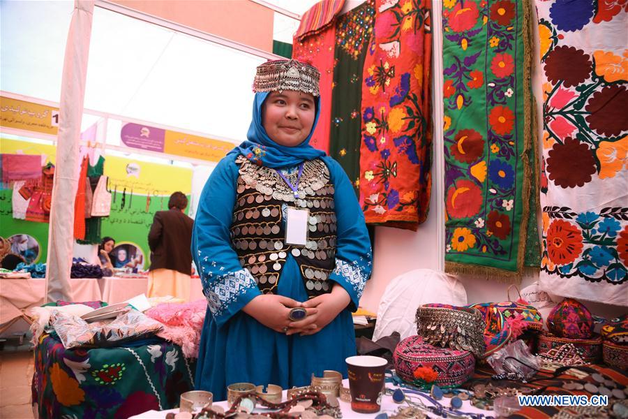 An Afghan woman poses for photos as she shows her products for visitors during a handicraft exhibition in Kabul, capital of Afghanistan, March 30, 2017. (Xinhua/Rahmat Alizadah)