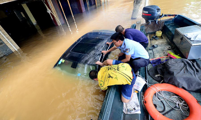 Policemen transfer people trapped by flood in S China's city