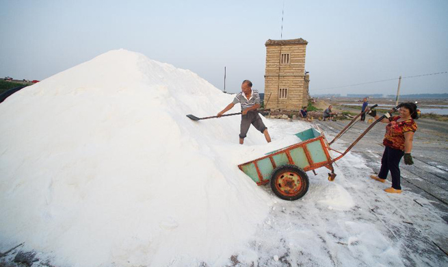 Workers collect salt at Shanyao saltworks in China's Fujian