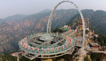 Yoga lovers practise at glass sightseeing platform in scenic spot of Beijing