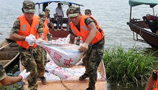 Soldiers reinforce dike threatened by rising water level in E China