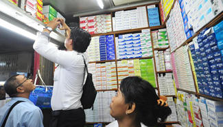Plainclothes police officers examine medicines during raid in drugstore in Indonesia