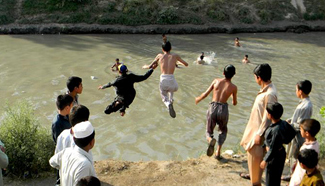 Boys jump in canal to cool off in Pakistan's Peshawar