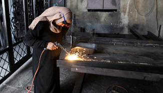 Palestinian woman works at metal workshop in Nablus