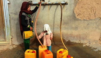 Afghans get water from public water pump in Kandahar