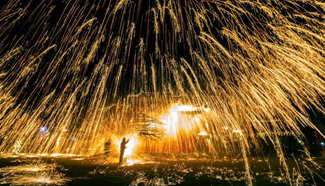 Performers spray hot iron water to simulate display of fireworks