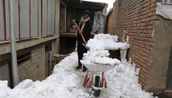 People clean snow in E Afghanistan