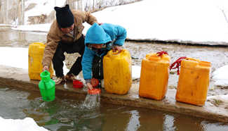 Afghan children carry barrels of water in Bamyan province