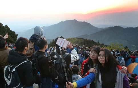 Tourists view sunrise at Hengshan Mountain scenic area in central China