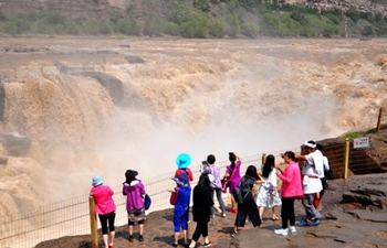 Tourists view Hukou Waterfall of Yellow River
