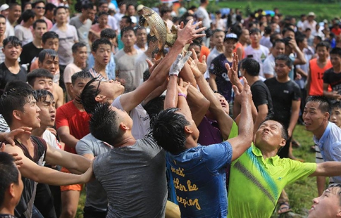 Villagers scramble to catch fish in S China's folk festival