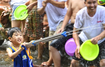 People play with water to enjoy coolness at SW China's ancient town