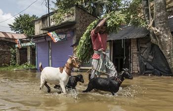 Villagers wade in flood water in eastern India's Kolkata