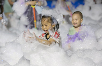 Children play in bubbles during fair in E China's Jiangsu