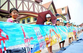 Children paint on scroll to depict hometown in E China