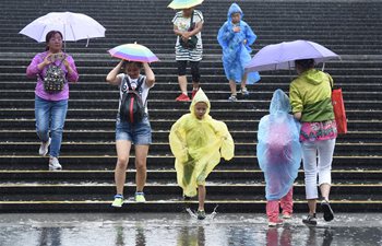 People walk in rain in Beijing
