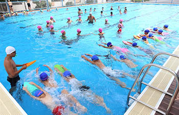 Students attend swimming class in E China's Shandong
