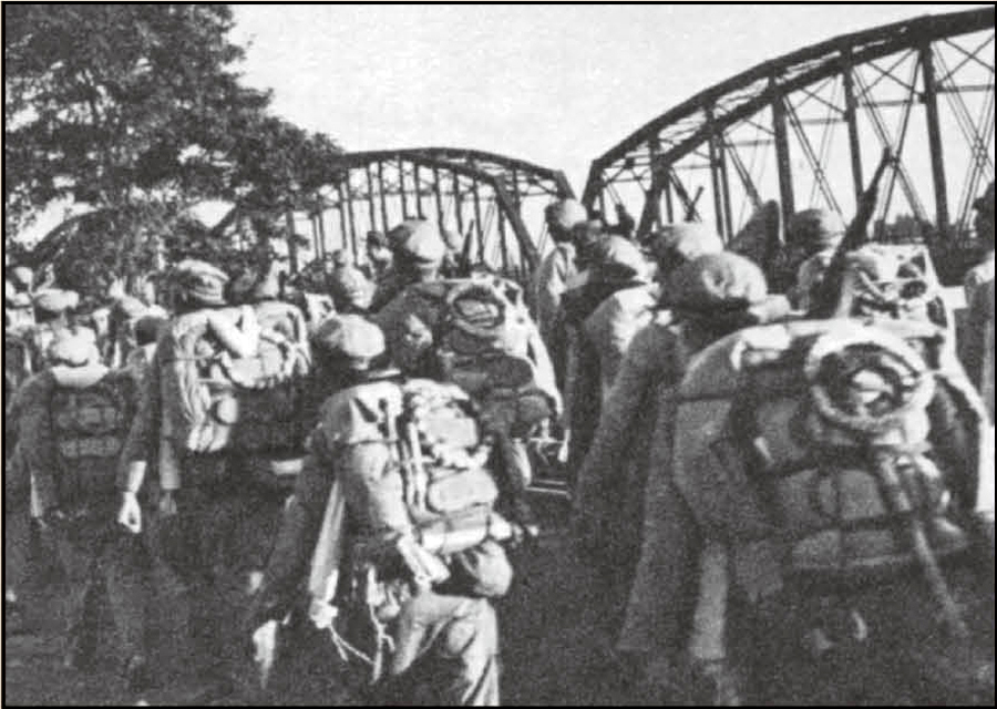 ↑部队编入中国人民志愿军序列，跨过鸭绿江。图为志愿军在跨过鸭绿江桥。