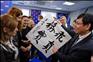 12月17日，在俄罗斯首都莫斯科，中国共产党专家组组长陈瑞峰（右）在向统一俄罗斯党宣介十八大精神时向现场的统一俄罗斯党青年组织代表赠送书法作品。新华社记者姜克红摄