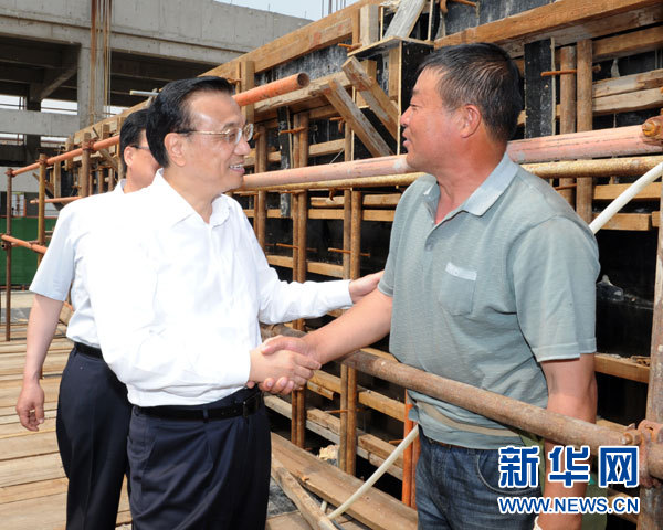 这是5月22日，李克强在德润污水处理厂考察在建污水处理工程时，与农民工交谈。 新华社记者谢环驰摄