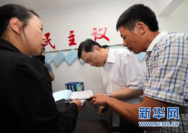 这是9月10日，张德江来到毕节双堰村村委会村民小组，仔细观看村小组日常工作记录，了解情况。 新华社记者刘卫兵摄